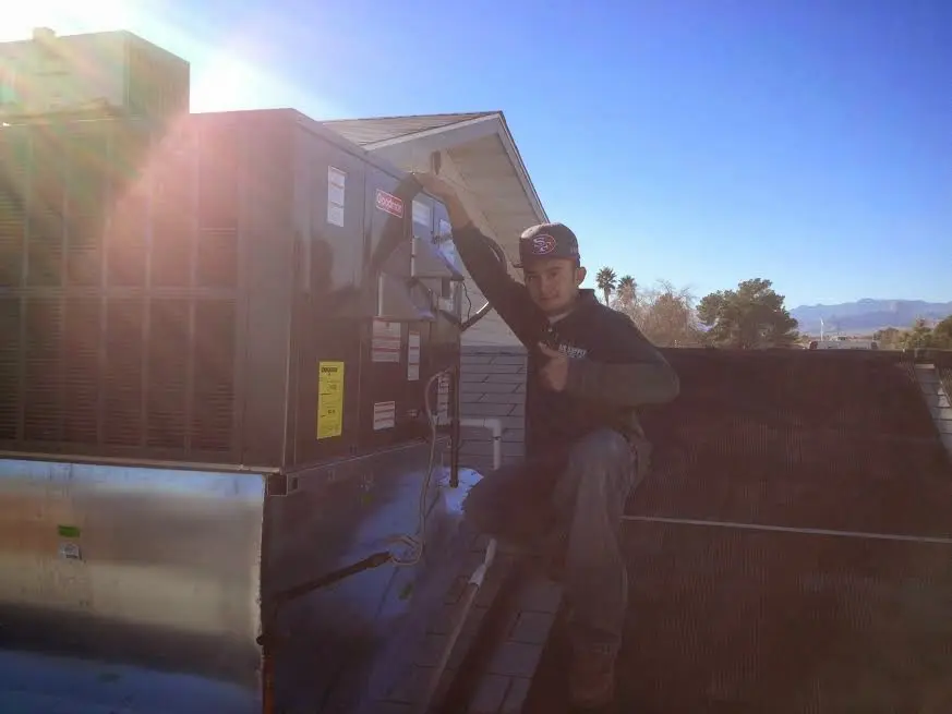 HVAC technician performing Heat Pump Repair on a rooftop unit in Oakwood